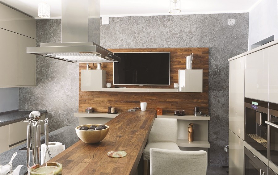 Image is of a wall-mounted TV in a modern kitchen. 