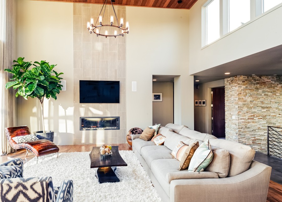 A beautiful, modern home with a beige living room, walls, and stone. 