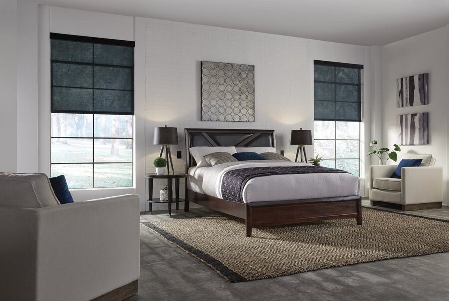 A bedroom with motorized shades raised up halfway to let in natural lighting.