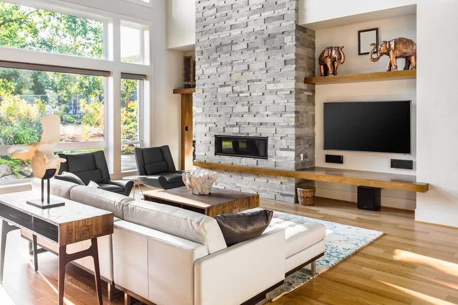 A family room featuring a TV, seating, and large windows to the left.